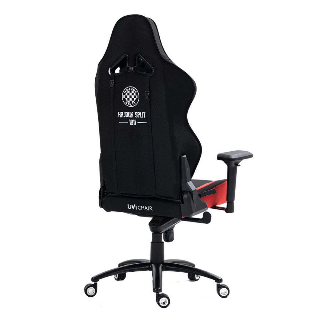 The product is an ergonomic gaming chair, specifically the UVI Chair model associated with the Hajduk Split brand. The image shows the back of the chair, which features a sleek black design with a logo and text that reads "HAJDUK SPLIT 1911." The chair has a high backrest, adjustable armrests, and is mounted