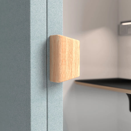 The product is an acoustic meeting pod, specifically the "Cottage" model. The image shows a close-up view of a textured blue panel with a wooden handle. The design emphasizes a modern and functional aesthetic, suitable for creating private meeting spaces.