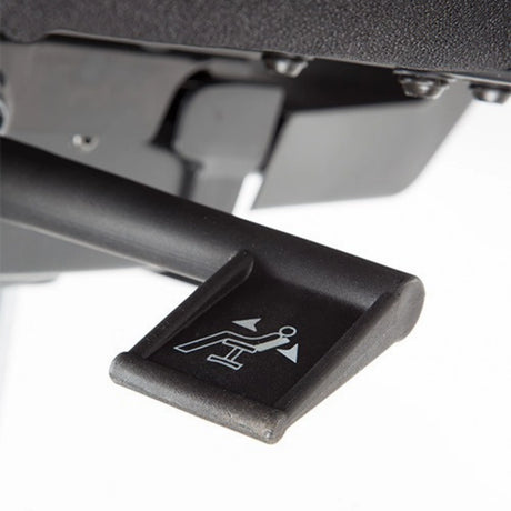 The product is an ergonomic office chair, likely from a basic line. The image shows a lever used for adjusting the chair's reclining feature, indicated by an icon of a person leaning back. The lever is designed for easy access and operation, enhancing user comfort.