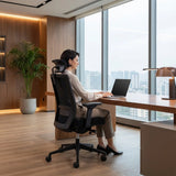 The image features an ergonomic office chair, designed for comfort and support during long hours of work. A woman is seated at a desk, using a laptop, with a modern office environment visible in the background, including large windows and a potted plant. The chair has a sleek design, emphasizing functionality and style.