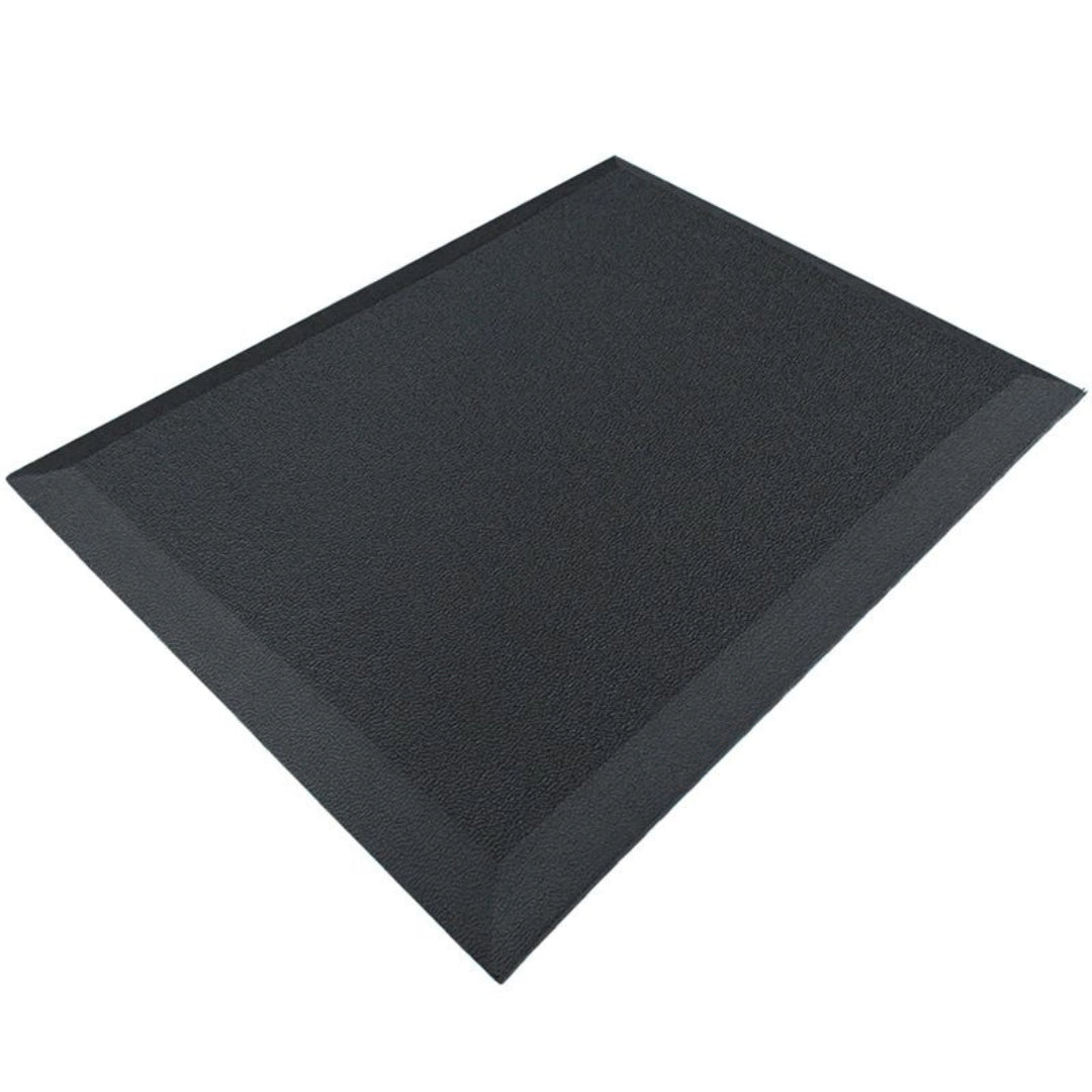 The image shows an ergonomic anti-fatigue mat, designed to provide comfort and support for individuals who stand for extended periods. The mat features a textured surface and beveled edges for safety, and it is predominantly black in color. This type of product is commonly used in offices, kitchens, and workspaces to reduce fatigue and improve posture.