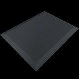 The product is an ergonomic anti-fatigue mat designed to provide comfort and support for individuals who stand for extended periods. It features a textured surface and beveled edges for safety and stability. The mat is primarily black, offering a sleek and professional look suitable for various environments.