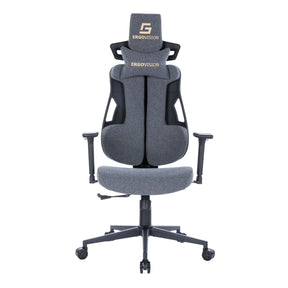 The image shows an ergonomic gaming chair, specifically the Ergovision Spartacus model. It features a modern design with a gray fabric upholstery, adjustable armrests, and a high backrest for support. The chair is equipped with a headrest and has a sturdy base with wheels for mobility.