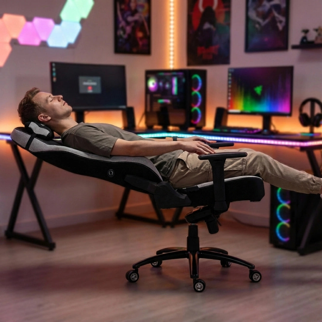 The product is an ergonomic office chair designed for gaming, specifically the UVI Alpha model. The image shows a person reclining comfortably in the chair, which features a modern design with adjustable armrests. The background includes a gaming setup with multiple monitors and colorful LED lighting, creating a vibrant atmosphere.
