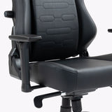 The product is an ergonomic office chair, specifically the UVI Elegant Business model. The image shows a close-up of the chair's backrest and seat, featuring a sleek black design with padded surfaces. It includes adjustable armrests and a lever for height adjustment, emphasizing comfort and functionality.