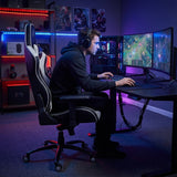 The image features an ergonomic gaming chair, specifically the UVI Sport XL in white. It shows a person sitting comfortably while gaming at a desk with dual monitors, surrounded by a well-lit gaming setup that includes colorful LED lights and gaming accessories.