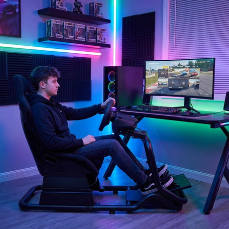 The image features a racing simulator seat, specifically the UVI Racing Seat Pro V2. It is designed for immersive gaming experiences, showcasing a user seated in a sporty, ergonomic position while holding a racing wheel. The background includes a gaming setup with ambient lighting, a monitor displaying a racing game, and a sleek computer tower, creating a modern gaming environment