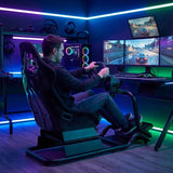 The image features a racing simulator seat, specifically the UVI Racing Seat Pro V2. It showcases a sleek, ergonomic design tailored for gaming, with a person seated and actively using a steering wheel setup. The background includes multiple monitors displaying racing games, along with gaming peripherals and ambient lighting, creating a vibrant gaming environment.