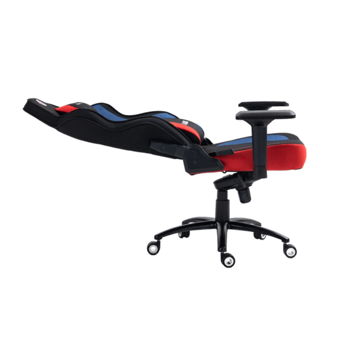 The product is a gaming chair, specifically the UVI X Hajduk model. The chair features a sleek design with a combination of black, red, and blue colors. It has a reclining backrest and adjustable armrests, making it suitable for long gaming sessions or office use. The chair is mounted on a five-point base with wheels for easy mobility